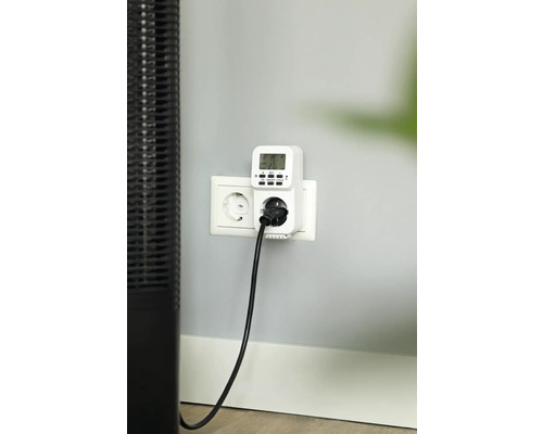 Digitale Zeitschaltuhr in Steckdose mit eingestecktem Stecker