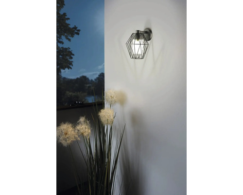 Wandleuchte mit geometrischem Lampenschirm und floraler Dekoration.