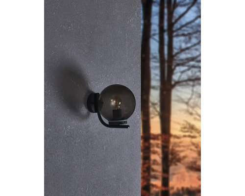 Wandleuchte mit runder, rauchfarbener Glasabdeckung und schwarzer Halterung an der Wand