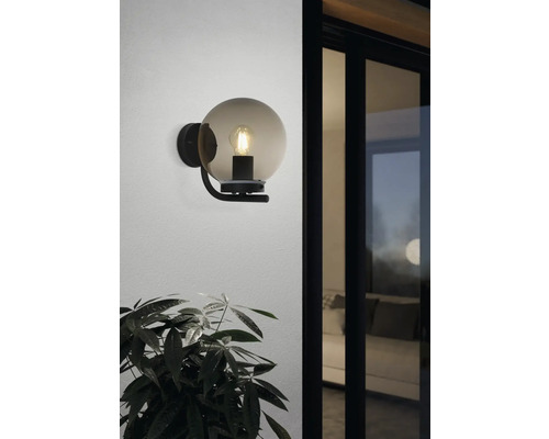 Wandleuchte mit einer Glaskugel und einem Leuchtmittel an einer Wand