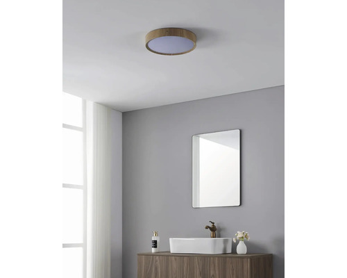 Badezimmer mit runder Deckenleuchte in Holzoptik, Spiegel und Waschbecken