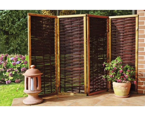 Sichtschutzzaun aus Weide mit Holzrahmen, kombiniert mit einer Laterne und einer Topfpflanze im Garten