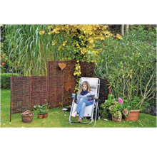 Gartenszene mit Weidenzaun, Liegestuhl und Frau beim Lesen im Garten