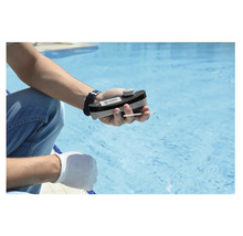 Eine Person misst die Wasserqualität eines Pools mit einem Pooltester.