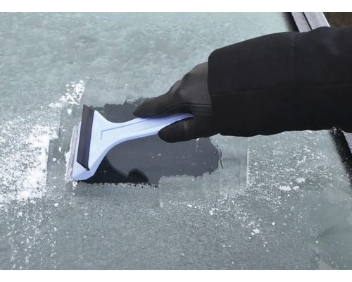 Hand mit Handschuh benutzt Eiskratzer auf Windschutzscheibe