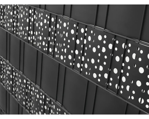 Nahaufnahme eines schwarzen Sichtschutzzauns mit kreisförmigen Aussparungen