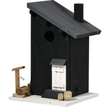 Schwarzes Vogelhaus mit dekorativen Holzfässern und Brunnen