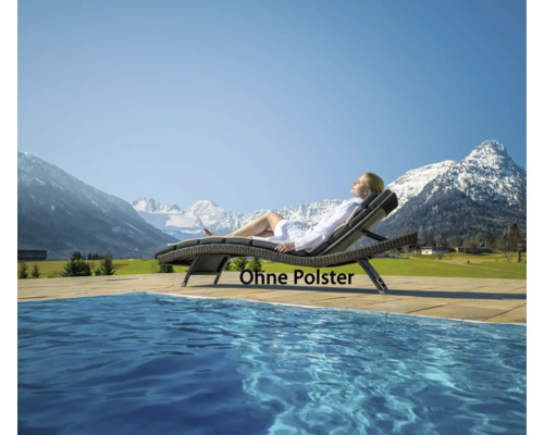 Frau entspannt auf einer Gartenliege aus Polyrattan ohne Polster am Pool vor Bergpanorama