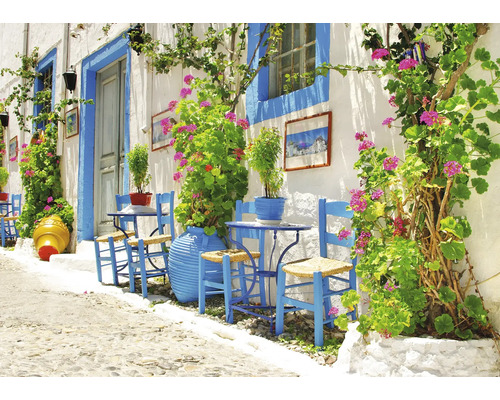 Helle Gasse mit blau gestrichenen Stühlen, Tischen und Pflanzenkübeln vor einer weißen Hauswand