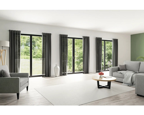 Helles Wohnzimmer mit Fensterfront, Vorhängen, Sofa und Teppich