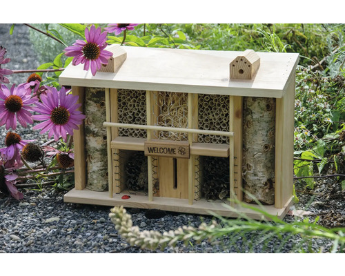 Insektenhotel aus Holz mit verschiedenen Füllmaterialien und dem Schriftzug Willkommen