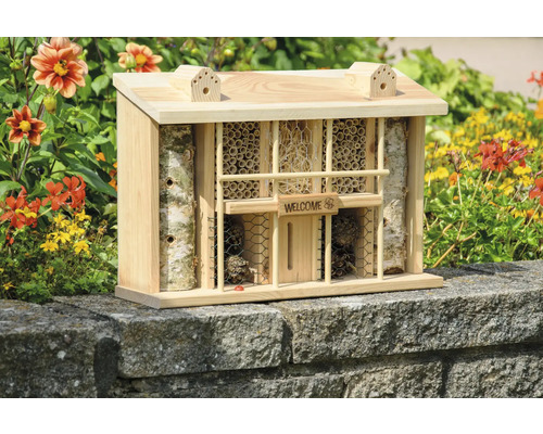 Insektenhotel aus Holz mit verschiedenen Füllmaterialien und einem Schild mit der Aufschrift Willkommen.