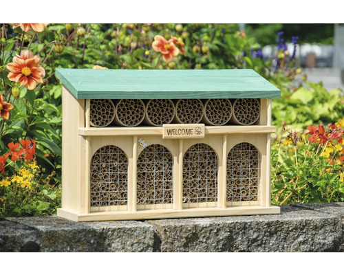 Insektenhotel aus Holz mit Dach und Röhren zur Insektenansiedlung im Garten.