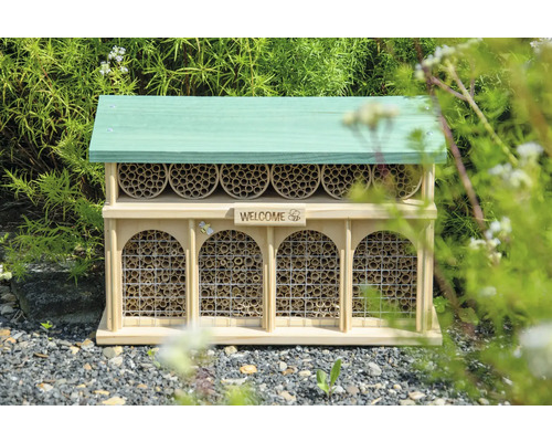 Insektenhotel aus Holz mit grünem Dach und Füllung aus Röhrchen