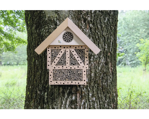 Insektenhotel aus Holz an einem Baumstamm befestigt