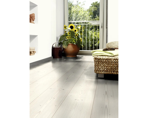 Heller Raum mit Holzfußboden, Sonnenblumen im Topf und gewebtem Hocker