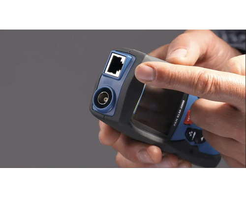 Nahaufnahme eines Netzwerkprüfgeräts in der Hand mit RJ45 und Koaxialanschluss