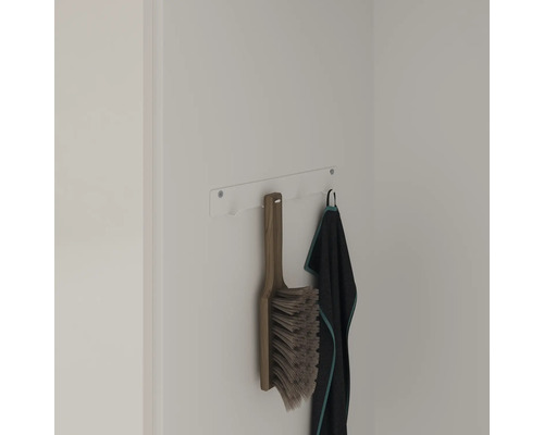 An der Wandhalterung hängen eine Kehrbürste und ein Handtuch.