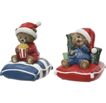 Zwei Teddybären-Figuren mit Weihnachtsmützen und Schlafanzügen auf Kissen