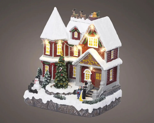 Beleuchtetes Weihnachtshaus mit Figuren und Baum als Dekoration