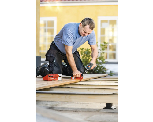 Mann arbeitet mit Schraubzwinge und Akkuschrauber an Holzterrasse