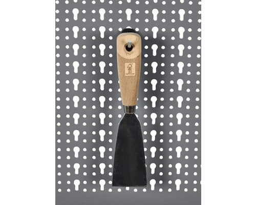 Spachtel mit Holzgriff an einer Lochwand