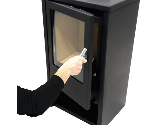 Kaminofen mit geöffneter Tür und Hand am Griff