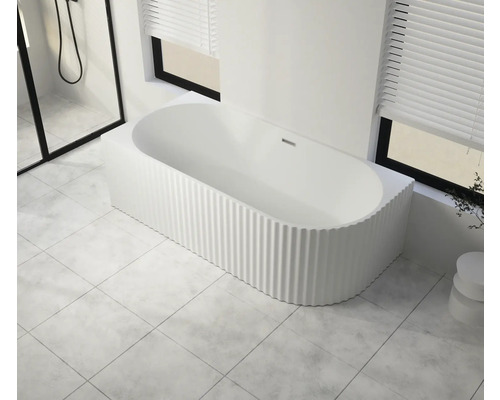 Freistehende Badewanne mit gerippter Oberfläche in einem hellen Badezimmer
