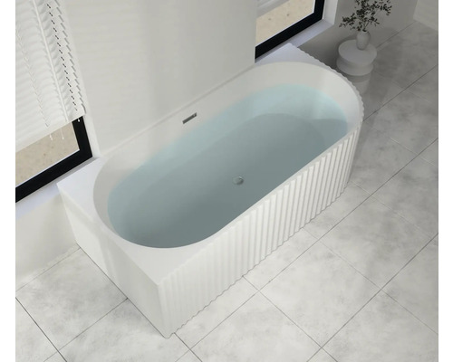 Freistehende Badewanne mit gerippter Oberfläche und Wasserfüllung im Badezimmer.