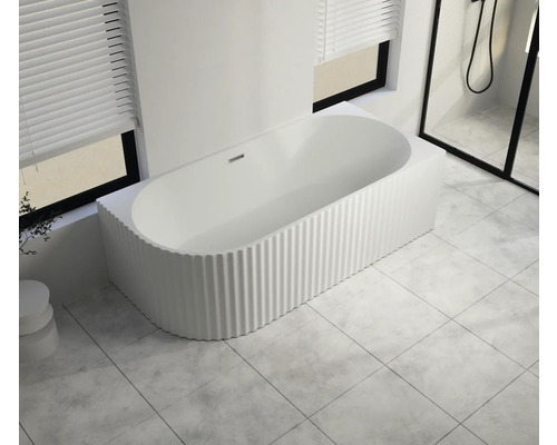 Freistehende Badewanne mit gerippter Oberfläche in einem hellen Badezimmer.