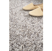 Detailaufnahme eines getufteten Teppichs mit Schuhen