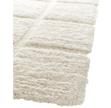 Detailaufnahme eines hellen, rechteckigen Teppichs