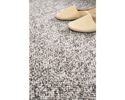 Detailaufnahme eines getufteten Teppichs mit zwei Schuhen