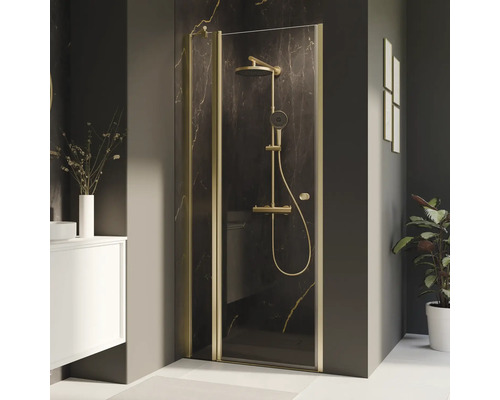 Duschabtrennung mit goldfarbenem Rahmen und Duscharmatur in einem Badezimmer.