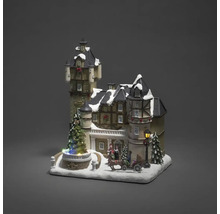 Dekorative Weihnachtslandschaft mit beleuchtetem Schloss, Figuren und Pferdeschlitten.