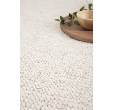 Detailansicht eines Teppichs mit Holzteller und Schale