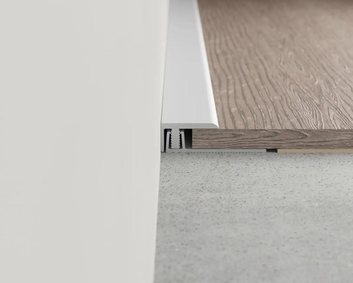 Detailansicht einer weißen Übergangsschiene zwischen zwei Bodenbelägen unterschiedlicher Höhe