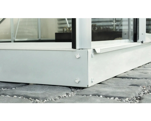 Detailansicht eines Gewächshauses mit Fundamentrahmen auf Pflastersteinen