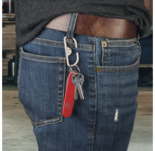 Person mit Schlüsselanhänger mit Mehrzweckmesser und Schlüssel an Jeans befestigt
