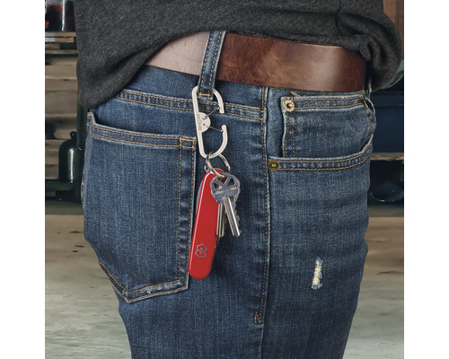 Person mit Schlüsselanhänger mit Mehrzweckmesser und Schlüssel an Jeans befestigt
