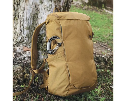 Rucksack aus Stoff mit Karabinerhaken vor einem Baum