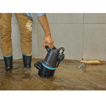 Mann benutzt eine Gardena Schmutzwasserpumpe in einem überfluteten Raum.