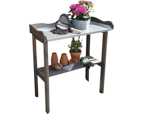 Gartentisch mit Blumen, Erde und Gartengeräten