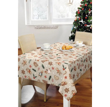 Esstisch mit Lebkuchenmuster-Tischdecke, Geschirr und Weihnachtsbaum für eine festliche Dekoration