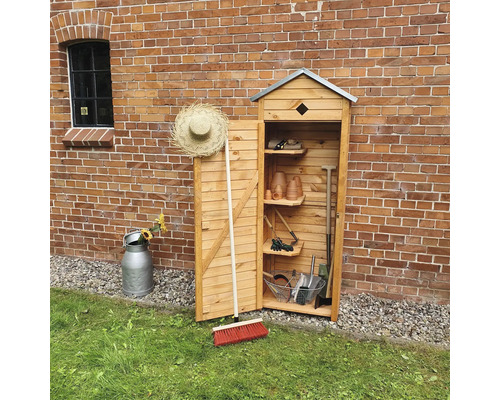 Gartenschrank aus Holz mit Gartengeräten vor einer Ziegelwand