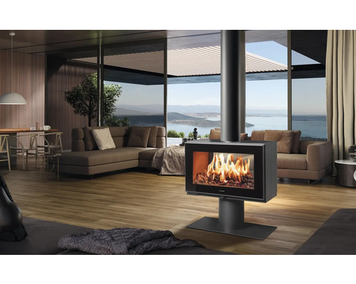 Wohnzimmer mit Kaminofen, Sofas und großem Fenster mit Seeblick