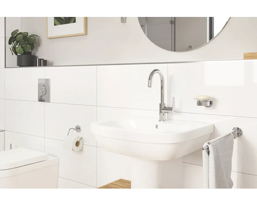 Badezimmer mit Waschbecken, Armatur, Spiegel und Toilette