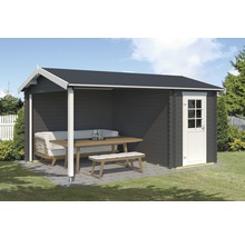 Graues Gartenhaus mit überdachtem Sitzbereich und Gartenmöbeln auf einer gepflasterten Terrasse