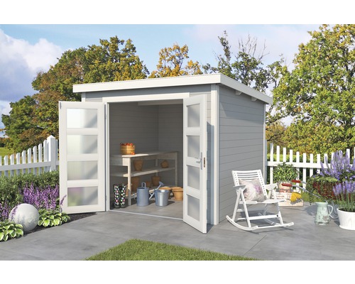 Gartenhaus mit geöffneten Türen, Werkbank und Gartengeräten in einem dekorierten Garten