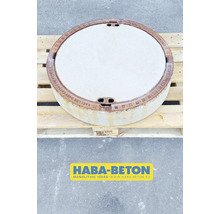 Runder Betonschachtdeckel auf einer Holzpalette